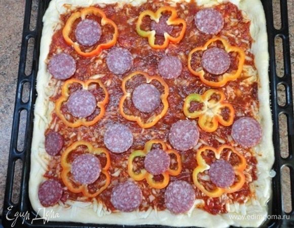 Покройте кружочками перца и салями. В оригинальном рецепте указывалось 12 кусочков салями, но нашлось много помощников и советчиков, которые вначале пробовали салями, а потом сказали, что колбасой пиццу не испортишь и потребовали выложить побольше кружочков, добавили еще и несколько кусочков чоризо.