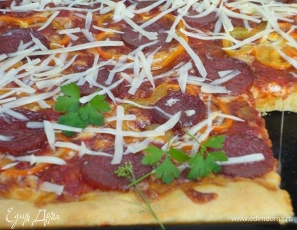 Готовую пиццу посыпаем тертым пармезаном и листочками базилика или любимой зелени (у меня это кинза).