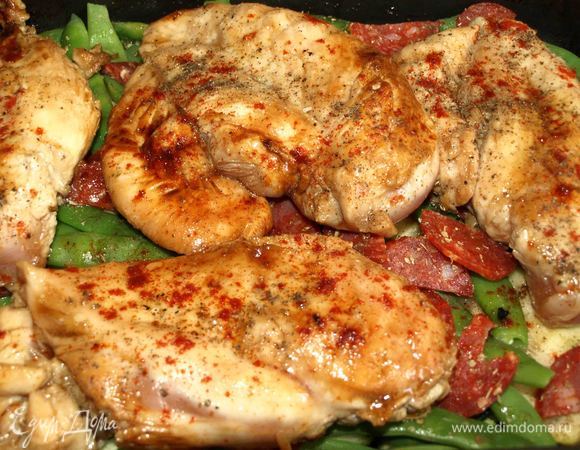 Выкладываем филе на чоризо и овощи. Поливаем 2 ложками маринада. Посыпаем черным перцем и сладким молотым перцем. Если необходимо посолить.