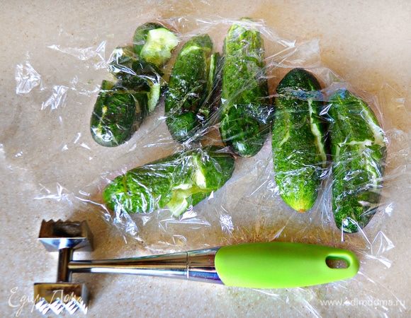 Накройте огурцы пленкой и слегка пройдитесь по ним скалкой или молоточком для отбивания мяса. Не переусердствуйте, иначе огурцы превратятся в кашу.