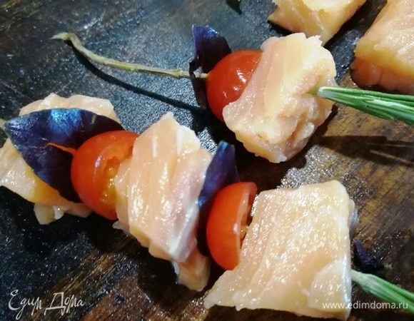 На веточку розмарина нанизываем кусочек лосося, половинку помидора черри, листик базилика. Чередуем.