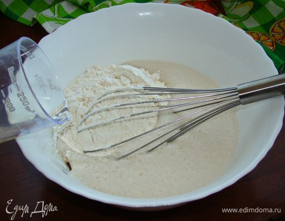 В смесь всыпать половину муки, перемешать. Влить половину масла и опять перемешать. Таким образом, всыпая муку и подливая растительное масло, замесить мягкое эластичное тесто.