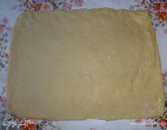 Тесто вынуть из холодильника. Разделить его в соотношении 1:2. Стол подпылить мукой и раскатать большую часть теста в прямоугольный пласт толщиной 5–6 мм. У меня получился пласт размером 24 х 32 см.