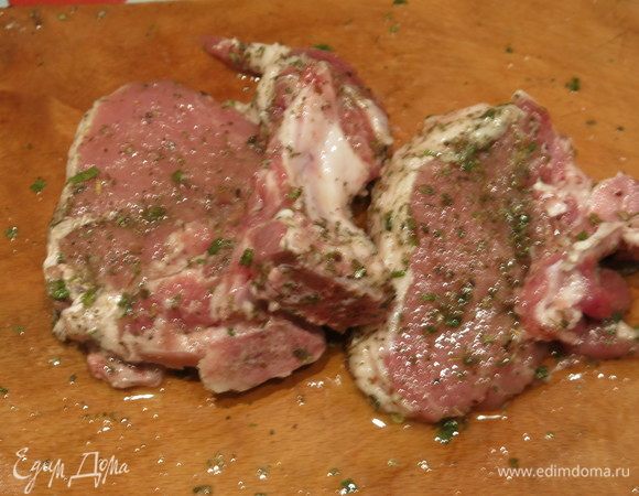 Подготовим продукты. Мясо нарезаем на отдельные кусочки на кости. Натираем маслом оливковым, солим, перчим, посыпаем травами.