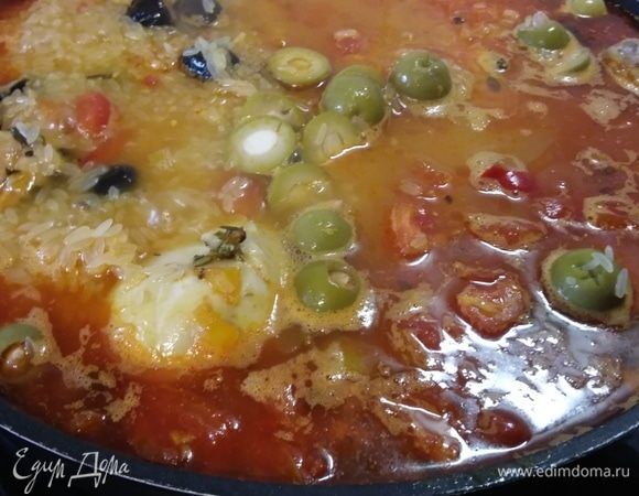 Выньте сковороду из духовки и добавьте рис. Расположите рис между кусочками курицы. Добавьте оливки, посолите и поперчите по вкусу. Мягко перемешайте рис в кастрюле. Накройте крышкой и готовьте в духовке 20 минут.