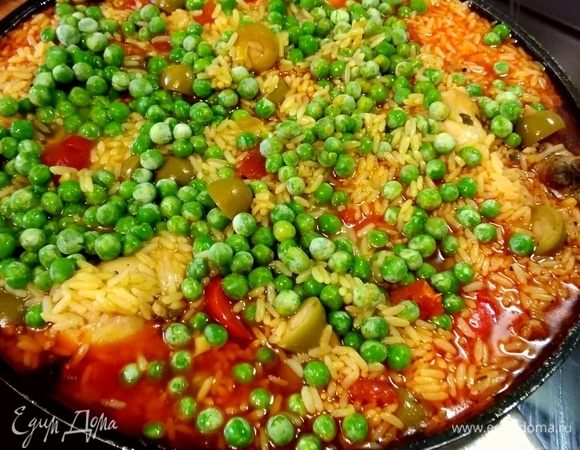 Выньте из духовки, добавьте горошек, накройте крышкой, готовьте, пока рис не поглотит почти всю жидкость. Проверяйте количество жидкости, возможно, ее необходимо будет добавить (это зависит от риса). Должно оставаться небольшое количество жидкости, которое рис впитает в течение последних нескольких минут «отдыха».