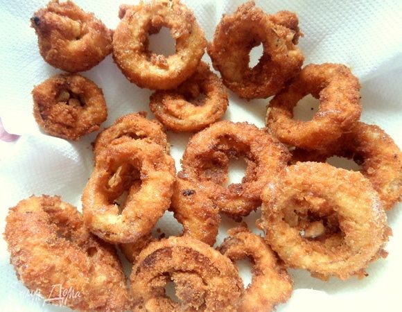 Готовые золотистые колечки вылавливаем и переносим на бумажное полотенце.