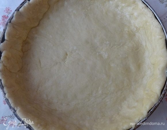 Форму смазать растительным маслом и обсыпать мукой, излишки стряхнуть. Тесто с помощью скалки перенести в форму. Выложить тестом дно и бока формы, формируя бортики.