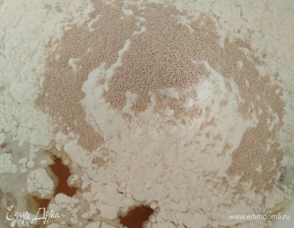 Муку просеять, смешать с сухими дрожжами, всыпать в миску. Я обычно оставляю 20–30 грамм муки и потом постепенно добавляю. Замесить тесто ложкой.