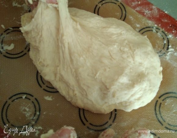 Перенести тесто на силиконовый коврик. Добавить оставшуюся муку и замесить тесто. Оно должно быть мягким и немного липким. На фото пыталась показать консистенцию теста. Если мука закончилась, а тесто сильно липнет, смажьте руки маслом.