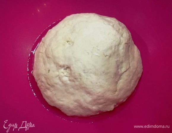 На дно миски наливаем столовую ложку растительного масла и перекладываем тесто. Видите, оно немного расплылось. Нормально, так и должно быть. Накрываем миску и оставляем тесто на 30–40 минут. За это время оно хорошо поднимется. В этом рецепте главное, чтобы тесто не перебродило, иначе ваши беляшики не получатся воздушными.