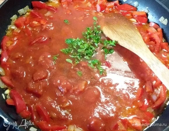 Через минуту добавить помидоры в собственном соку, предварительно их измельчив, и орегано. Тушить несколько минут. Посолить и поперчить, добавить щепотку сахара и острый соус (по желанию).