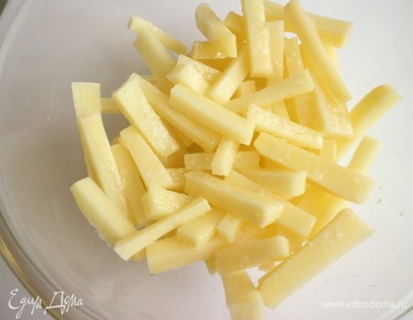 Приготовить картофель фри. Лучше для этого брать те сорта картофеля, в которых содержится меньше крахмала, в противном случае картофель следует подержать какое-то время в воде, затем обсушить полотенцем. Духовку разогреть до 200°C. Почистить картофель, нарезать брусочками толщиной 1 см, посолить, сбрызнуть оливковым маслом, перемешать.