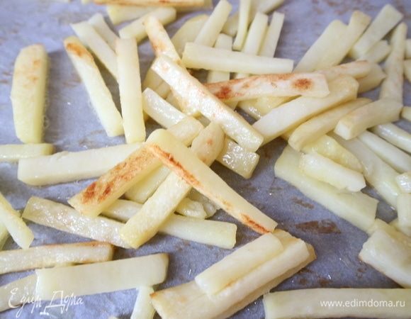 Поместить в духовку на противне, застеленном бумагой для выпечки. Запекать до румяной корочки. Запеченный таким способом картофель содержит меньше масла после приготовления, чем классический картофель фри.