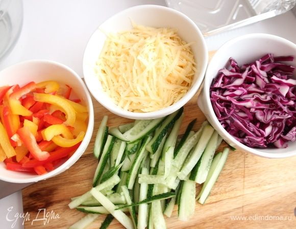 Перец нарезать тонкими пластинами, краснокочанную капусту нарезать тонко, огурцы — тонкой соломкой, сыр натереть на крупной терке.