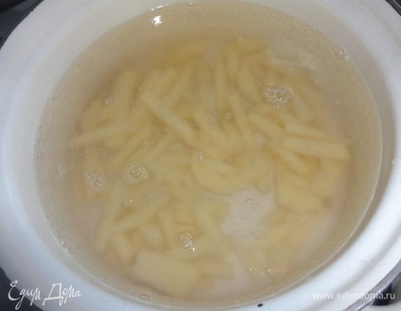 В кипящую воду положить картофель, дать повторно закипеть, немного посолить и варить до полуготовности.