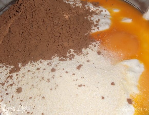 Творог смешать со сметаной. Добавить какао, яичные желтки, манку. Перемешать.