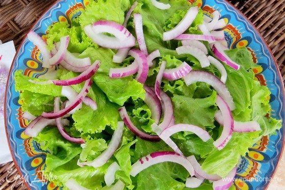 Сладкий салатный лук нарезать полукольцами. Выложить на листья салата.