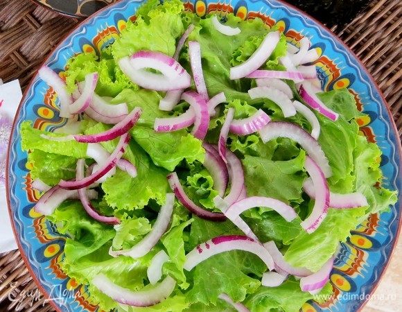 Сладкий салатный лук нарезать полукольцами. Выложить на листья салата.