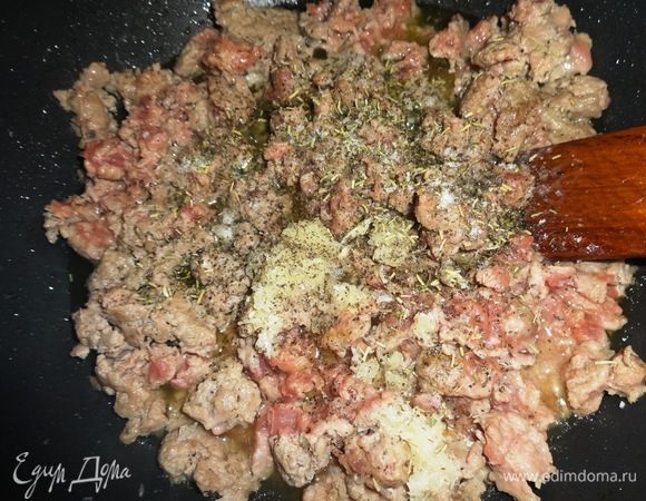 В сковороду налить масло, разогреть, положить фарш, посыпать его солью, перцем, прованскими травами, перемешать. Обжарить в течение нескольких минут, разбивая лопаткой комочки. В конце обжаривания положить пропущенный через пресс чеснок.