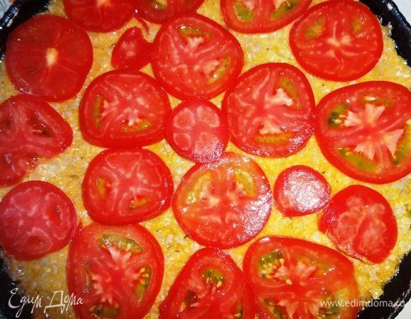 Помидоры вымыть, обсушить, нарезать тонкими кольцами. Уложить кольца помидоров на запеканку. Поставить запеканку в духовку, разогретую до 180°C, и выпекать в течение 35–40 мин.