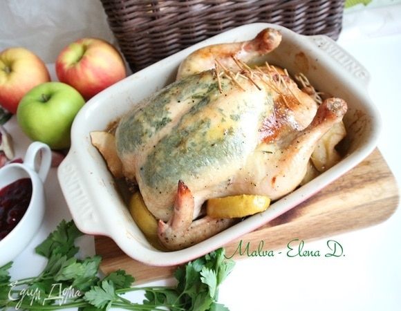 Поставить курицу в духовку примерно на 1 час 25 минут, пока курица не зарумянится. Во время запекания периодически поливать курицу выделяющимся соком. Через 25–30 минут после начала выпечки добавить в форму с курицей яблоко, у которого удалена семенная часть, порезанное на дольки.