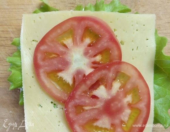 Булочки смазать йогуртом, положить зелень, сыр, ломтик помидора, котлету.