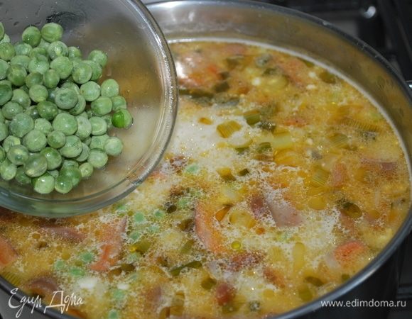 В конце добавим зеленый горошек, черный молотый перец и свежую зелень. Перемешаем и проварим одну минуту.