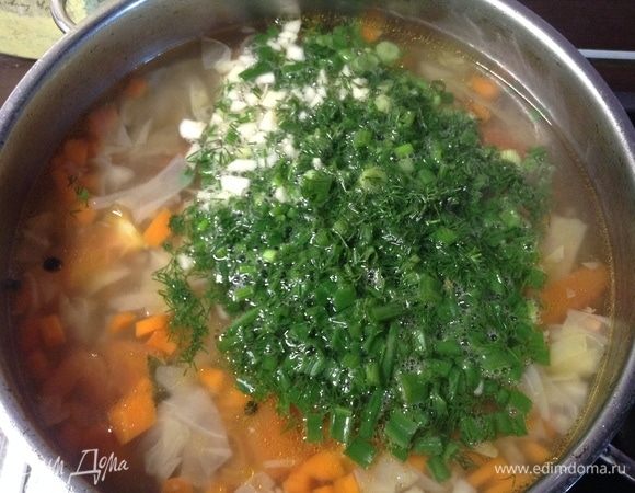 Как овощи сварились почти (минут 15 пусть кипят, не больше), выключаем огонь, всыпаем зелень и чеснок.