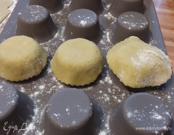 Взять формы для маффинов. У меня силиконовая. Если у вас другие, то их нужно сначала смазать маслом и посыпать мукой с обратной стороны. Кружки теста аккуратно поместить на выемки от маффинов и слегка прижать, придавая форму корзиночки.