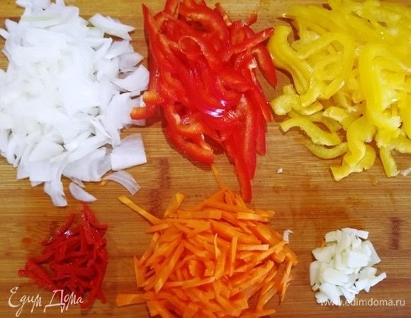 Нарезаем овощи, кроме баклажана, очень тонкой, примерно одинаковой соломкой. Чеснок рубим.