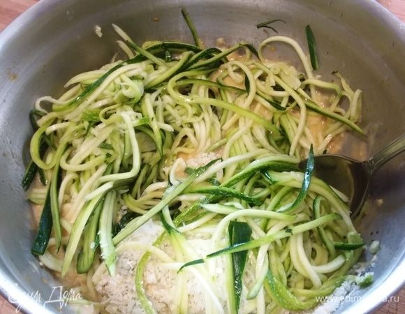 Добавить в яичную смесь спиральки цукини и базилик. Перемешать.