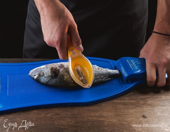 Дораду выпотрошите, удалите жабры. Положите на доску для рыбы с зажимом для хвоста Faberlic. Тугой зажим с острыми зубцами фиксирует хвост рыбы и позволяет значительно ускорить очистку чешуи. Почистите рыбу с помощью скребка для чистки рыбы Faberlic. Удобный скребок эргономичной формы значительно облегчит процесс чистки рыбы от чешуи, которая собирается в специальном контейнере и не разлетается в разные стороны, сохраняя порядок на рабочем месте на кухне.<br />
 
