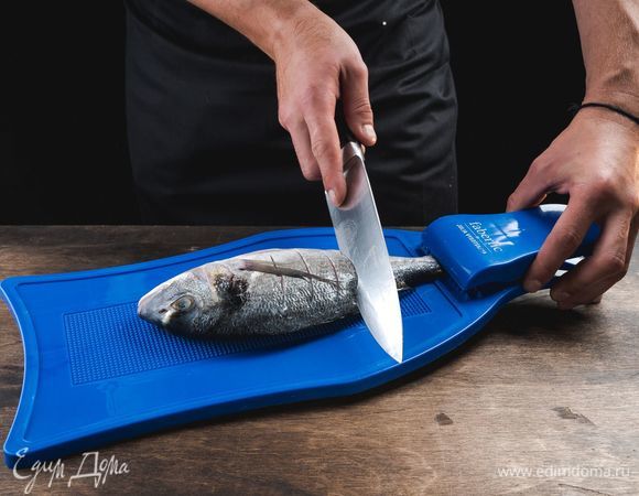 С каждой стороны тушки сделайте по 4 глубоких надреза. Посолите и поперчите дораду.<br />
 