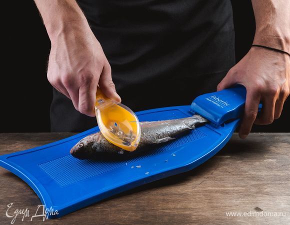 Подготовьте форель. Положите на доску для рыбы с зажимом для хвоста Faberlic. Тугой зажим с острыми зубцами фиксирует хвост рыбы и позволяет значительно ускорить очистку чешуи. Благодаря присоскам с обратной стороны доска не будет скользить по столу. Почистите рыбу с помощью скребка для чистки рыбы Faberlic. Удобный скребок эргономичной формы значительно облегчит процесс чистки рыбы от чешуи, которая собирается в специальном контейнере и не разлетается в разные стороны, сохраняя порядок на рабочем месте на кухне.<br />
 