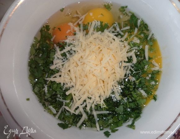 В чашку разбить яйца, добавить петрушку, половину оставшегося сыра, соль, перец. Массу взбить венчиком или вилкой.