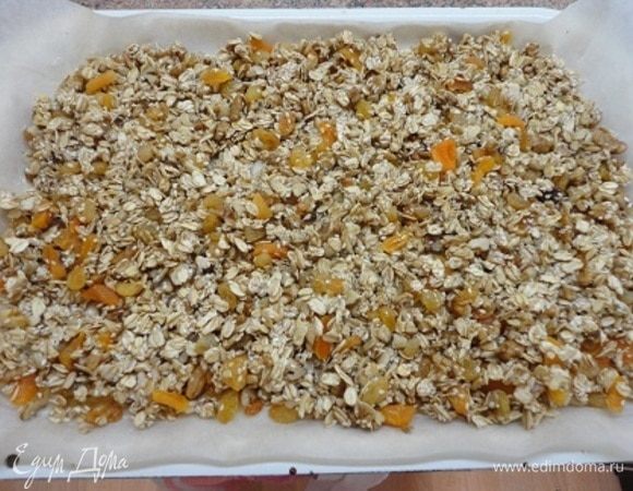 Противень выстилаем бумагой, смазываем ее сливочным маслом и равномерно распределяем смесь по поверхности.