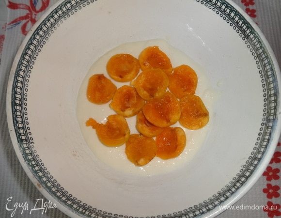 В чашку с шарообразным дном положить немного желейной массы. Выложить слой абрикосов срезом вверх.