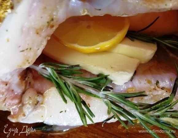 В брюшко укладываем сливочное масло, дольку лимона, веточки розмарина.