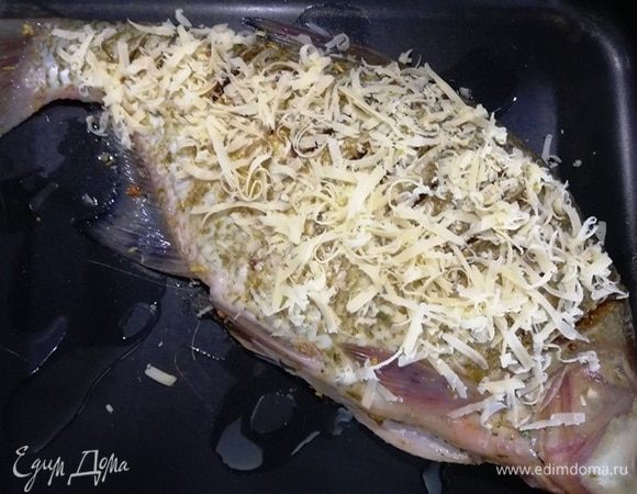 Перекладываем леща на противень, посыпаем тертым сыром.