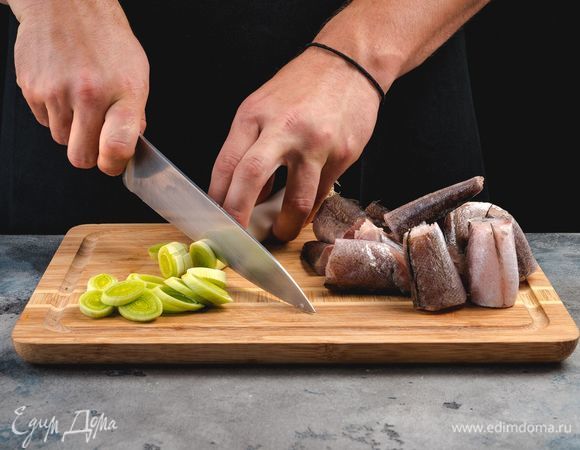 Разрежьте рыбу на куски среднего размера и нашинкуйте лук-порей.