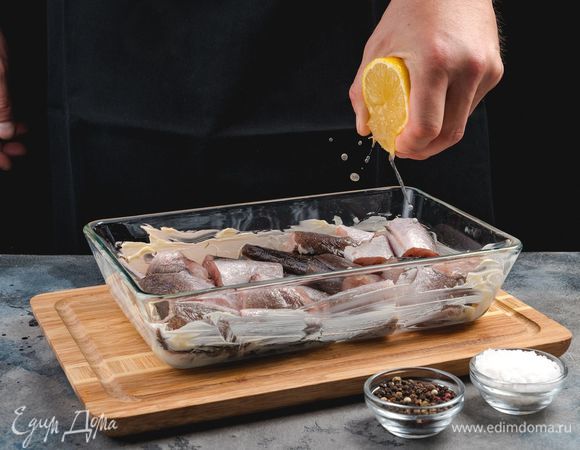 В смазанную маслом форму для запекания выложите рыбу и сбрызните лимонным соком. Затем посыпьте специями и оставьте мариноваться.