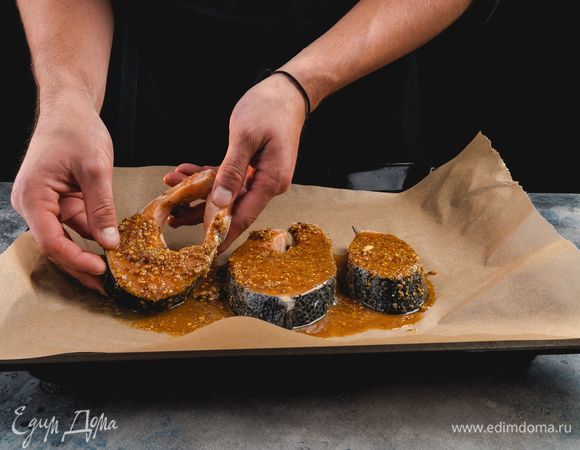 Противень застелите пергаментом, выложите рыбные стейки. Запекайте в предварительно разогретой до 180–200°С духовке в течение 25 минут.<br />
 