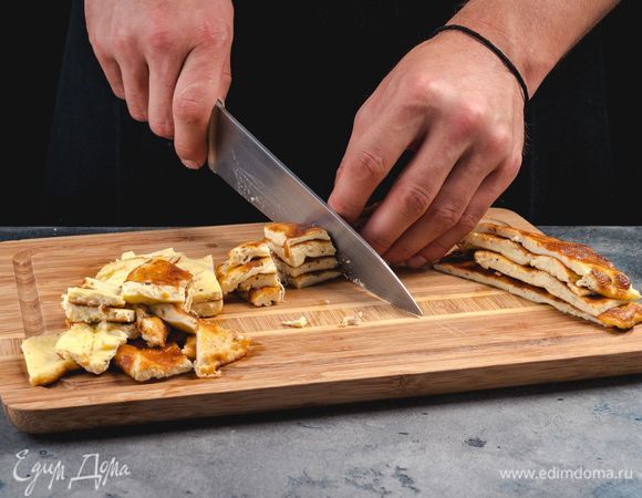 Приготовьте омлет. Для этого смешайте яйца, тертый сыр, сливки и поджарьте омлет на оливковом масле с обеих сторон. Омлет остудите и нарежьте небольшими полосками.<br />
 