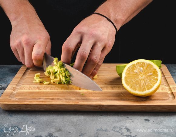 Авокадо очистите от кожуры, удалите косточку, мякоть нарежьте маленькими кубиками. Сразу сбрызните авокадо лимонным соком, чтобы сохранить зеленый цвет.<br />
 