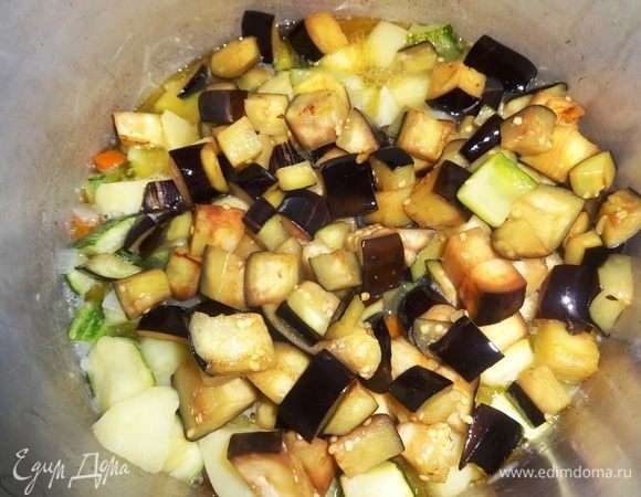 Положить обжаренные баклажаны в кастрюлю, перемешать.