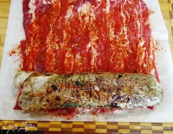 Посыпаем бекон паприкой и выкладываем на край вырезку.