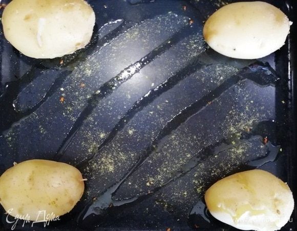 На противень наливаем немного растительного масла. По углам выкладываем вареный картофель.