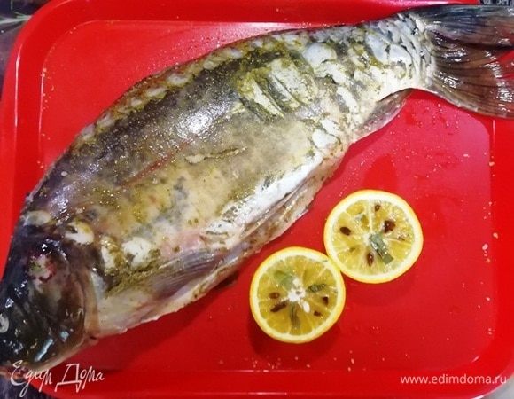 Солим и перчим рыбу внутри и снаружи. Поливаем соком половины апельсина. Довольно крупный апельсин разрезаем на две части. В мякоть втыкаем звездочки аниса и лавровый лист.