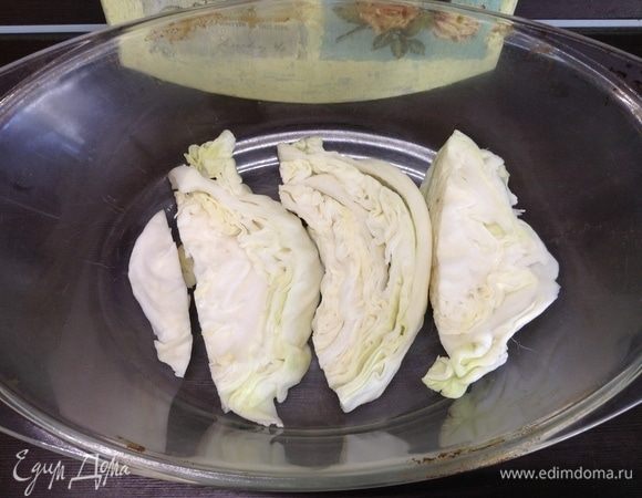 На дно глубокой посуды (у меня стеклянная с крышкой) толстенькими кусками укладываем капусту — подушка для «приема» лишнего жирка во время запекания и воздушная прослойка.